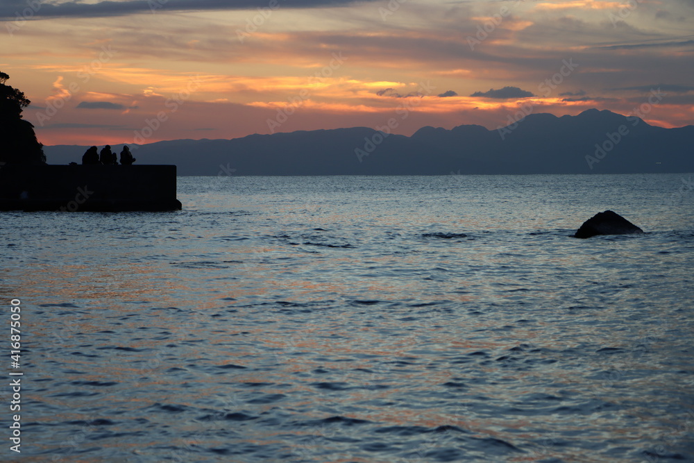 夕方に江ノ島から見る伊豆半島と防波堤のシルエット