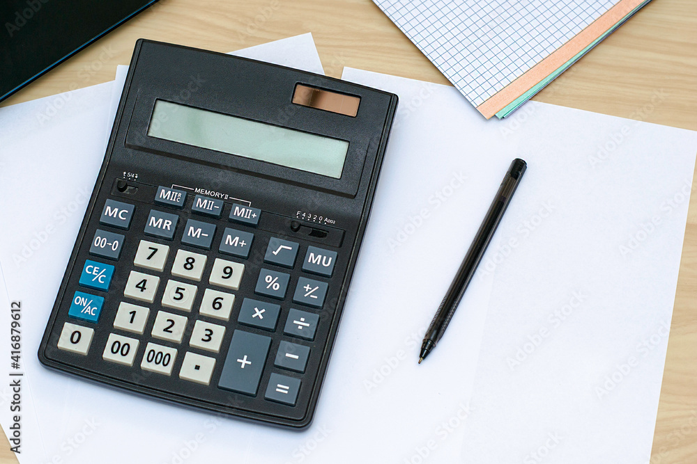 accounting calculator fountain pen notebook and notepad on sheets of white paper accounting calculator fountain pen notebook and notepad on sheets of white paper