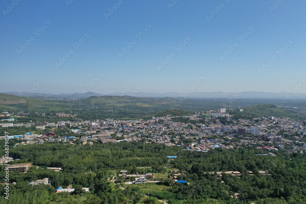 Aerial photography of beautiful city. Green hills and houses crisscross the city