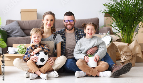 Cheerful family sitting of floor in new apartment