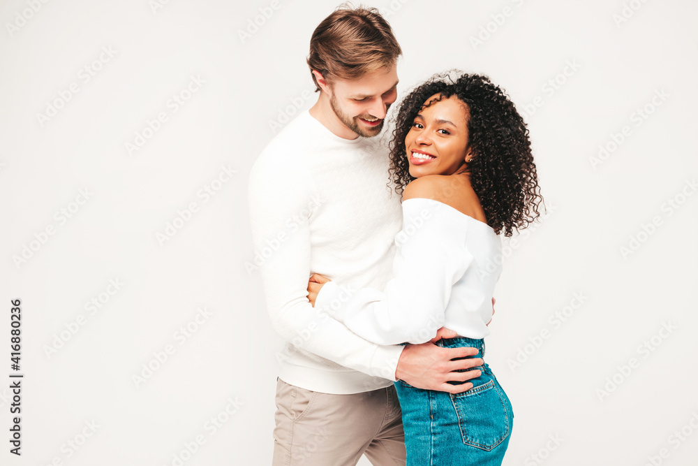 Smiling beautiful woman and her handsome boyfriend. Happy cheerful multiracial family having tender moments on grey background in studio. Multiethnic models hugging. Embracing each other.Love concept Smiling beautiful woman and her handsome boyfriend. Happy cheerful multiracial family having tender moments on grey background in studio. Multiethnic models hugging. Embracing each other.Love concept