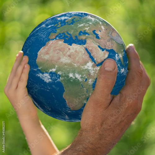 Fototapeta Naklejka Na Ścianę i Meble -  Family holding Earth planet in hands.Elements of this image furnished by NASA