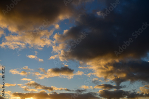 Arrière-plan de texture de ciel au coucher du soleil, aux nuages colorés jaune et sombre sur fond de ciel bleu