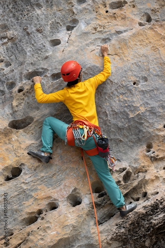 Woman rock climber climbing on the cliff