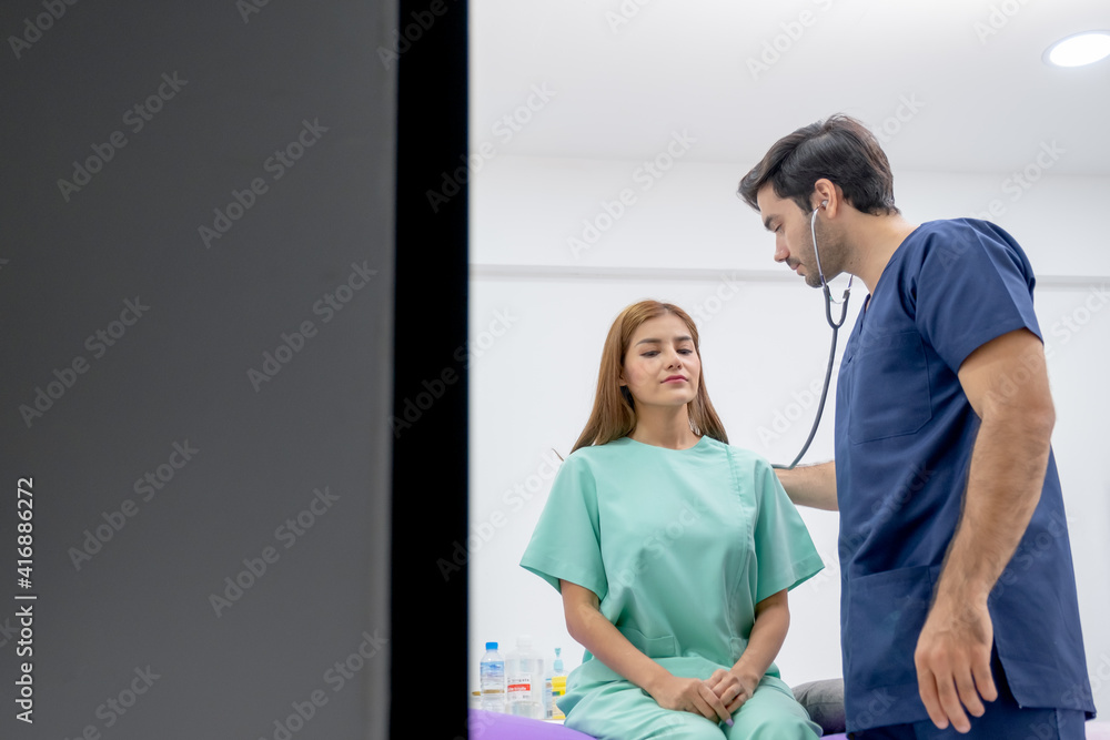 Fototapeta premium Caucasian doctor use stethoscope to analyze the symptom of Asian patient in beauty clinic or hospital.