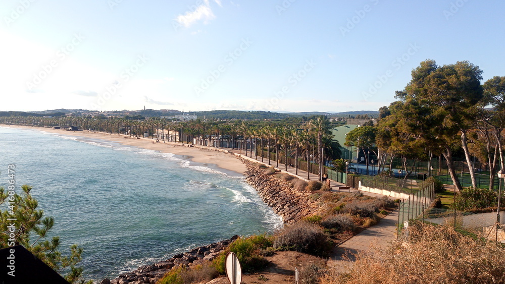 View of the embankment in Spain. Promenade with palm trees on the mediterranean sea