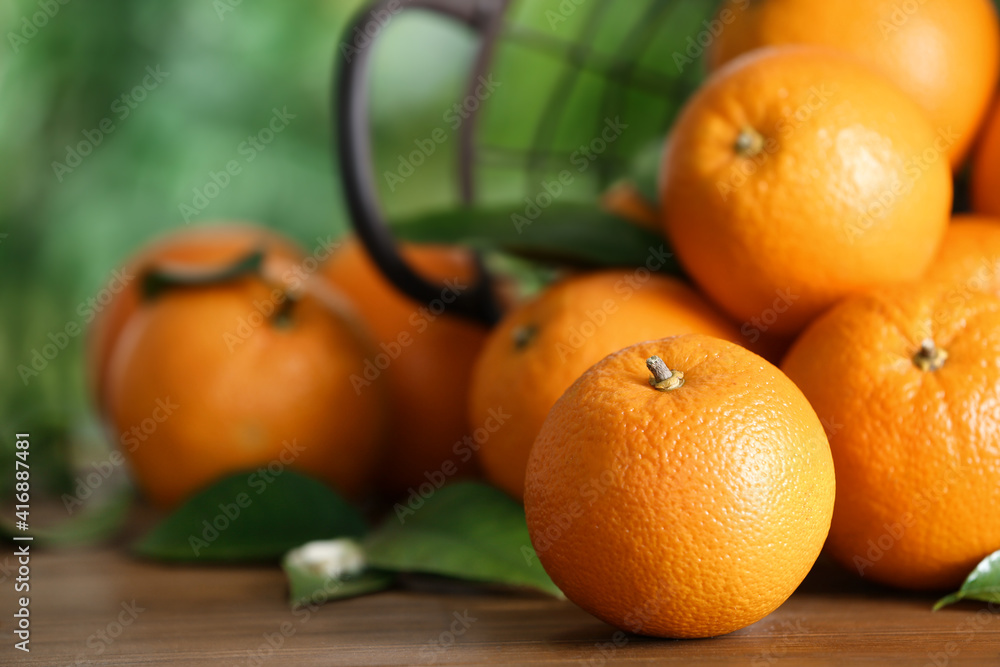 Fresh ripe oranges on wooden table against blurred background. Space for text