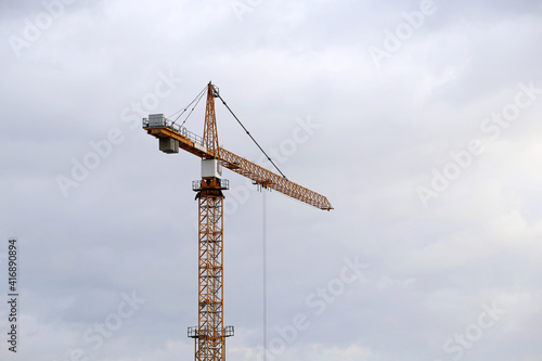 Construction crane on cloudy sky background. Building industry