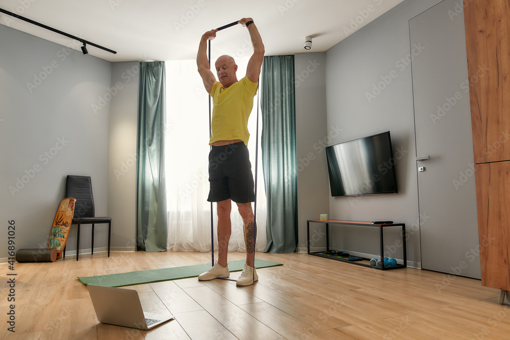 Sports man leading workout online on laptop Sports man leading workout online on laptop
