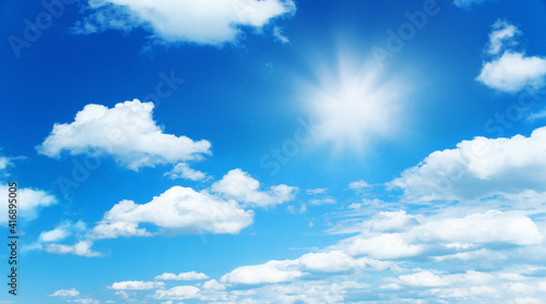 Sunny background  blue sky with white clouds and sun as summer or spring natural background.