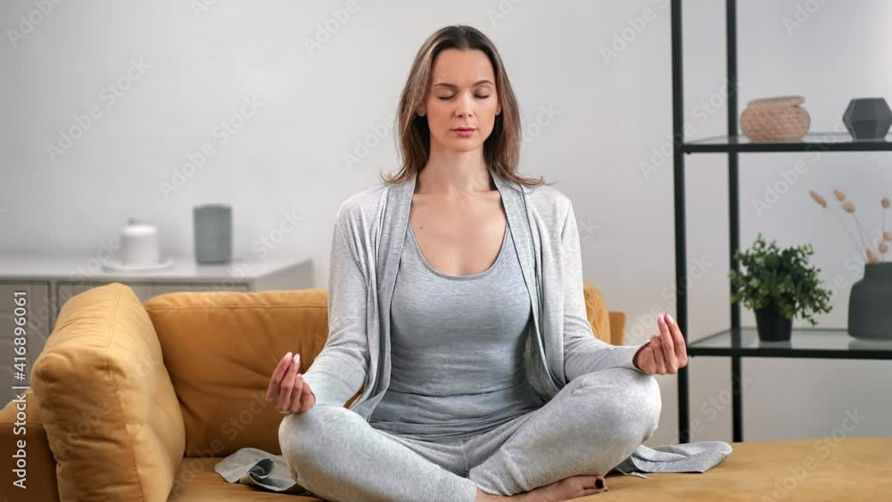 Pleasant lady practicing morning yoga breathing exercise in lotus position. Wide shot on RED camera Pleasant lady practicing morning yoga breathing exercise in lotus position. Wide shot on RED camera