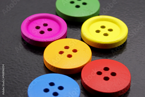 close-up colorful buttons for sewing on black background