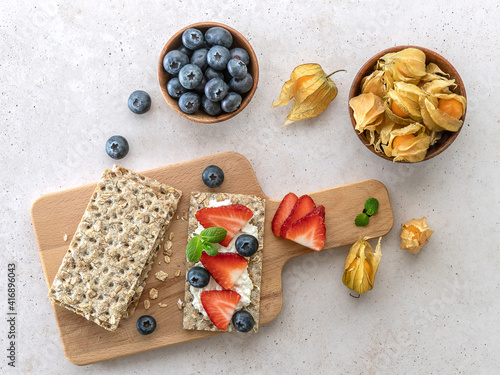 Photos Rye oats crispbread with cottage cheese, mint leaves, fresh strawberries, and blueberries