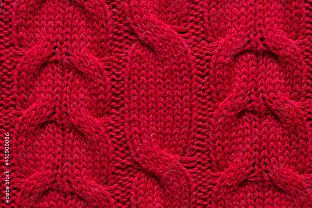 The texture of a red knitted sweater. Textured background knitting.