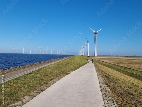 Windmill village indrustial wind mill by the lake Ijsselmeer Nehterlands. renewable energy green energy photo