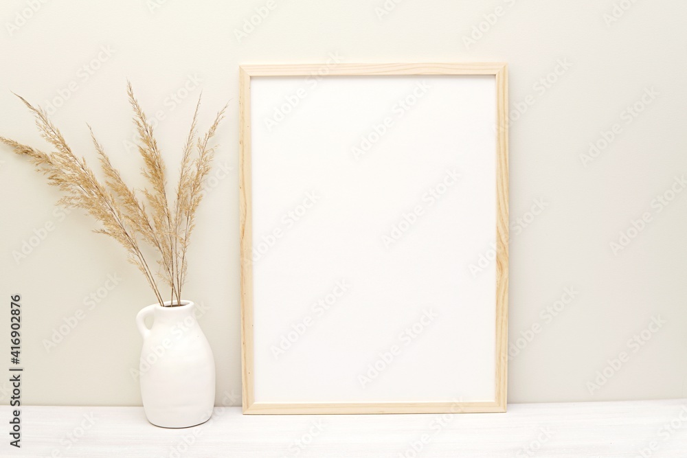 Vertical wooden frame mockup in boho style living room interior for wall art presentation. Vertical wooden frame mockup in boho style living room interior for wall art presentation.