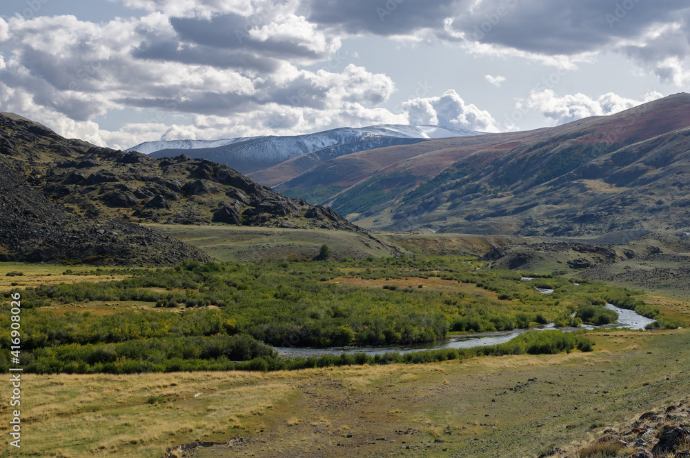 Dramatic desert steppe river valley on a highland mountain plateau with ranges of hills on a horizon storm skyline Dramatic desert steppe river valley on a highland mountain plateau with ranges of hills on a horizon storm skyline