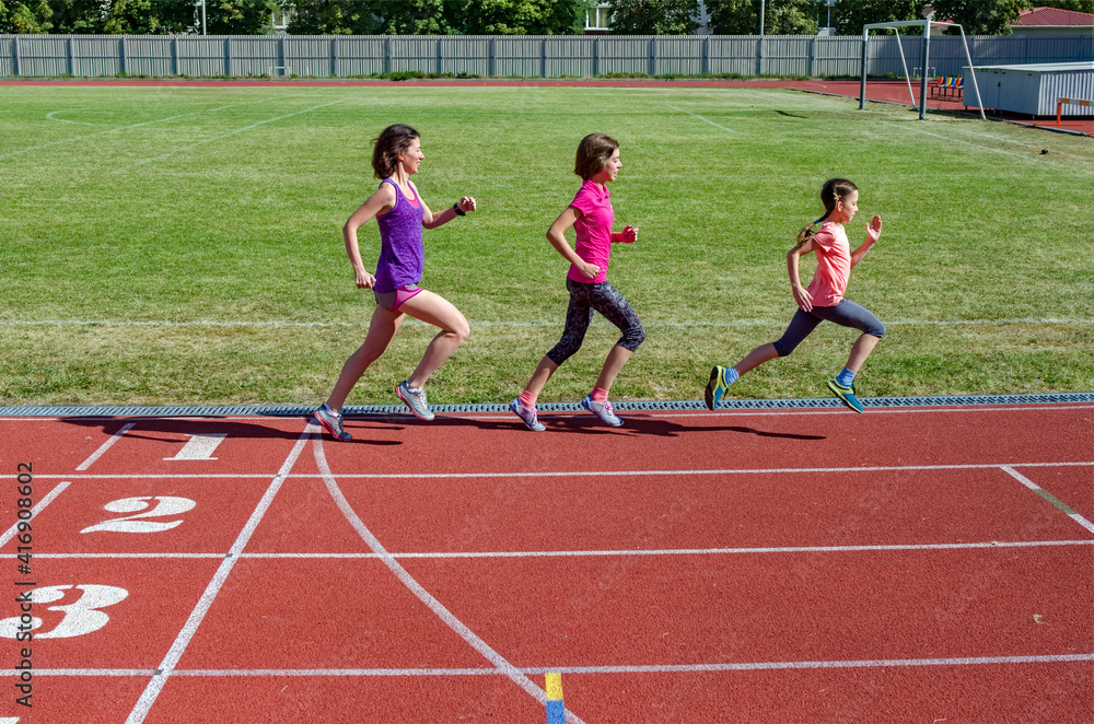 Obraz premium Family fitness, mother and kids running on stadium track, exercise with children and sport healthy lifestyle concept