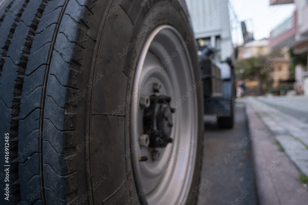 rear right wheel of a truck parked near a sidewalk in city low angle view rear right wheel of a truck parked near a sidewalk in city low angle view