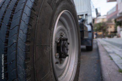 rear right wheel of a truck parked near a sidewalk in city low angle view