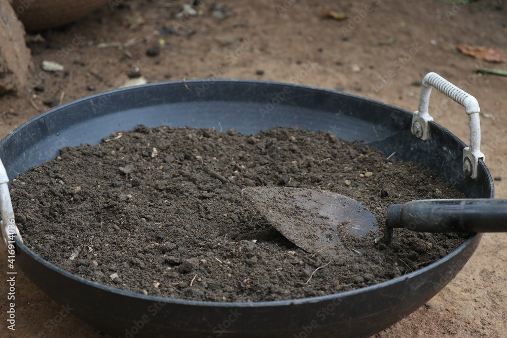 Potting soil with trowel kept on basket. Organic fertilized black soil used for potting or filling garden tray with trowel Potting soil with trowel kept on basket. Organic fertilized black soil used for potting or filling garden tray with trowel