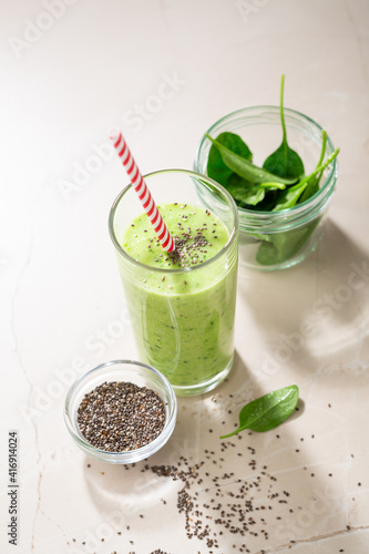 Vegetarian green smoothie from avocado, spinach leaves and chia seeds on stone table. Selective focus