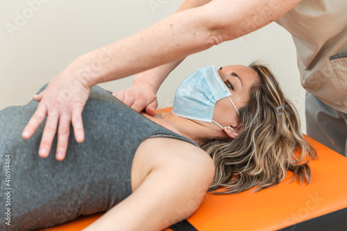 Фотография Physiotherapist and patient in Global Postural Re-education session, with pandemic protection mask