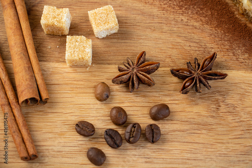 beautiful composition of anise, brown sugar, cinnamon and coffee beans on a wooden background