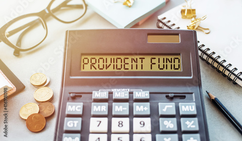 Word PROVIDENT FUND written on calculator on office table. photo