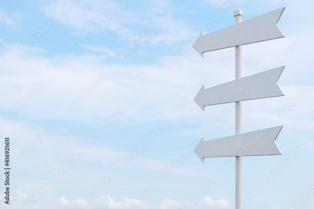 White painted wooden sign with an arrow pointing out on sky White painted wooden sign with an arrow pointing out on sky