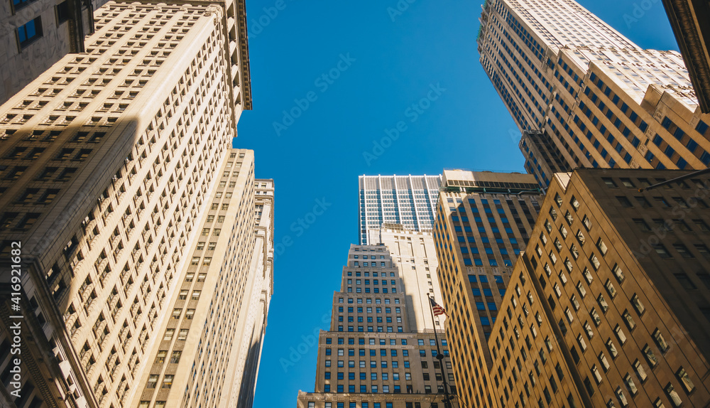 Giant skyscrapers dominate city streets of Wall Street. Lower Manhattan, New York City Giant skyscrapers dominate city streets of Wall Street. Lower Manhattan, New York City