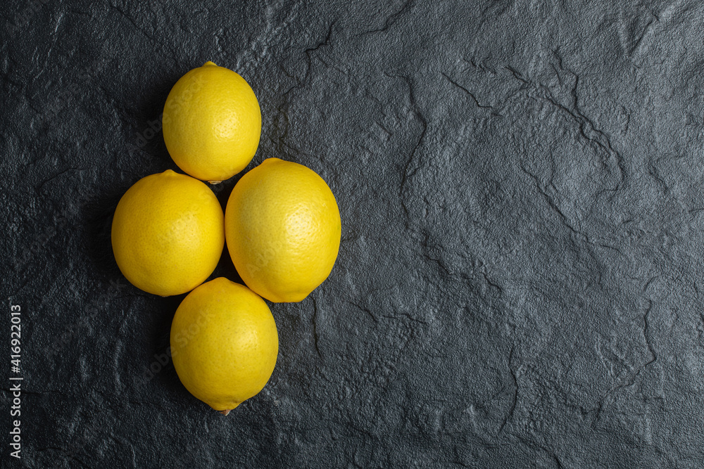 Top view of ripe fresh lemons over black stone background Top view of ripe fresh lemons over black stone background