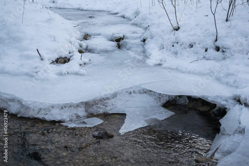 Water flowing in partially frozen creek © Matej