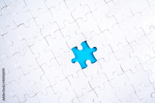 White Puzzle pieces with one piece removed, blue color underneath.