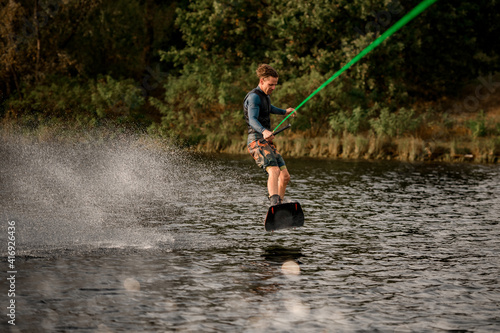 view on man balancing on wakeboard and rides down on wave