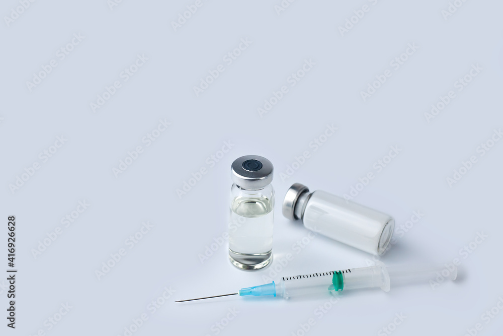 Vaccine vial, medicine drug bottles and syringe injection on a white background. Vaccination, immunization, treatment to Covid-19. Close-up. Copy space. Vaccine vial, medicine drug bottles and syringe injection on a white background. Vaccination, immunization, treatment to Covid-19. Close-up. Copy space.