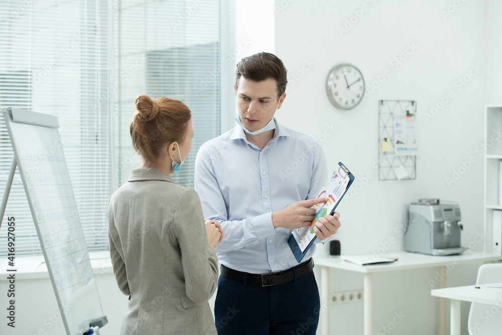 Obraz premium Two young elegant accountants discussing financial data at meeting in office