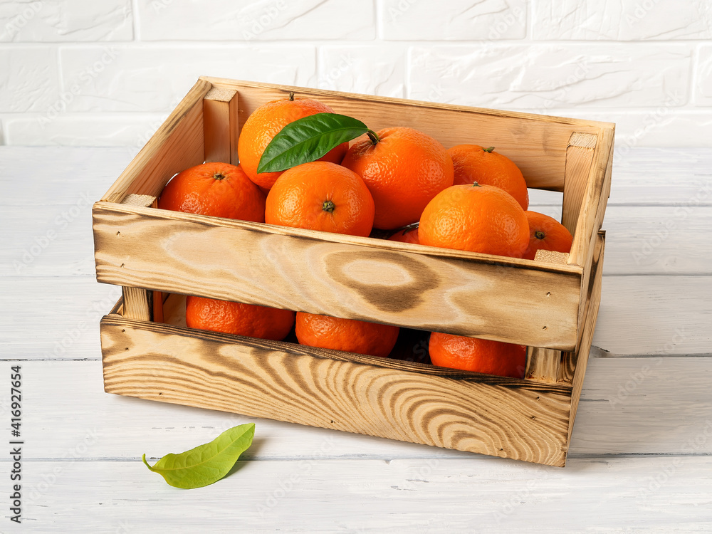 Wooden crate with sweet ripe orange tangerines on a kitchen table. Fresh  citrus in a wood box. Eco-friendly rustic style containers for fruits and  vegetables. Vegetarian and healthy eating. Photos | Adobe