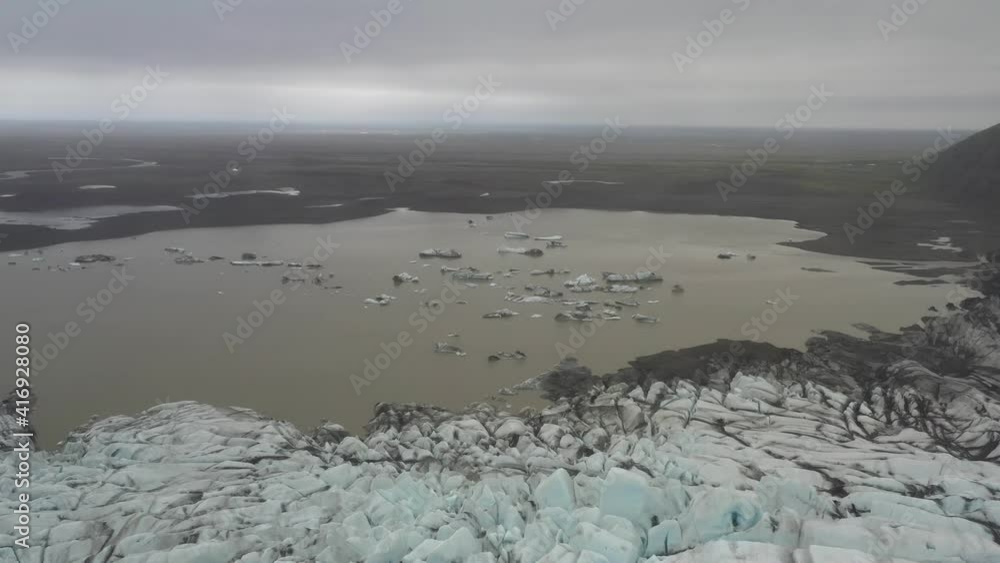 Flying over melting glacier in Iceland. Dirty glacier lake aerial view Flying over melting glacier in Iceland. Dirty glacier lake aerial view