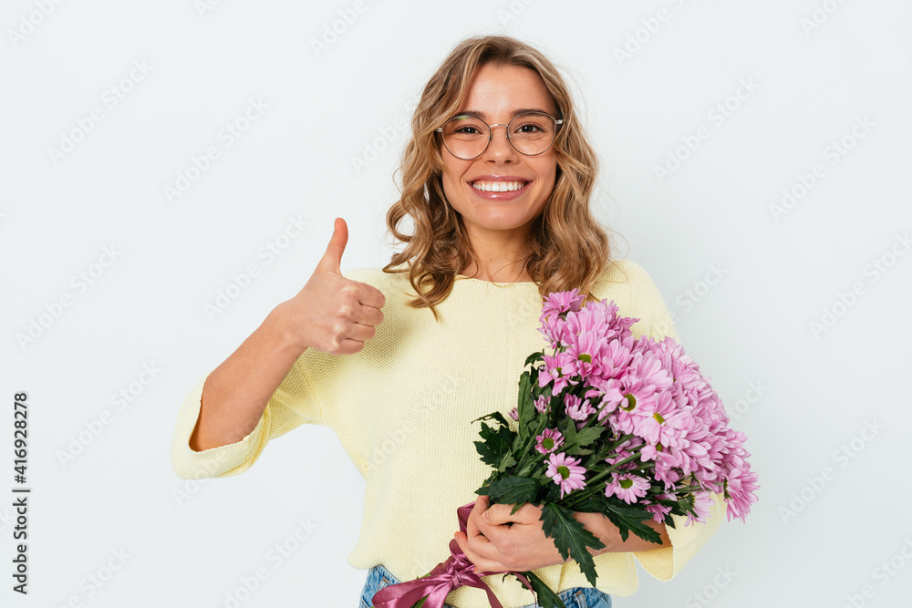 Young happy woman wearing glasses holding bouquet of flowers Young happy woman wearing glasses holding bouquet of flowers