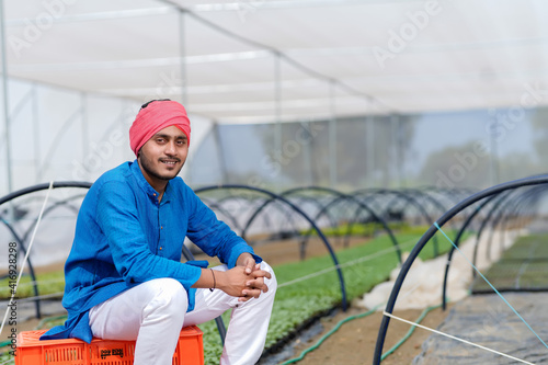 Young indian farmer at greenhouse or poly house