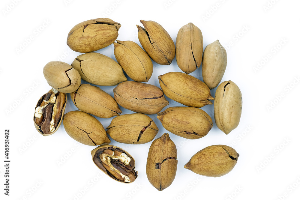 Obraz premium Pecan in a shell on a white background top view. Pecans, in shell and slightly chopped.