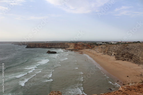 Coastal landscape of a beach with waves and a cliff