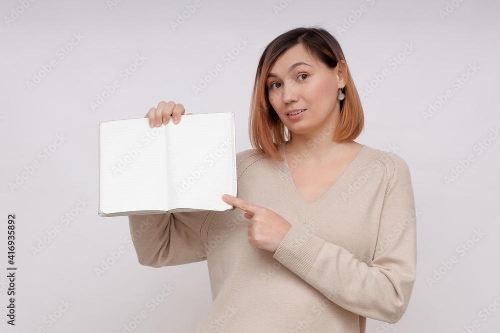Young woman showing open book with copy space on white background Young woman showing open book with copy space on white background