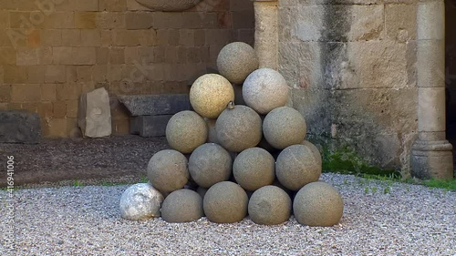Rhodes Greece .Medieval cannon balls of the time a small birdi found refuge on them photo