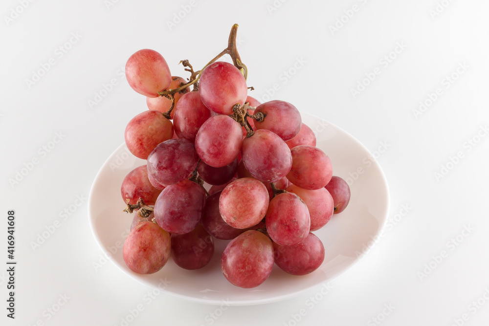 bunch of fresh grapes lies on a dinner plate bunch of fresh grapes lies on a dinner plate