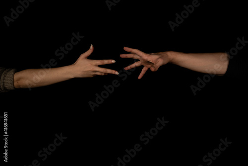 Man and woman holding hands isolated on black background.