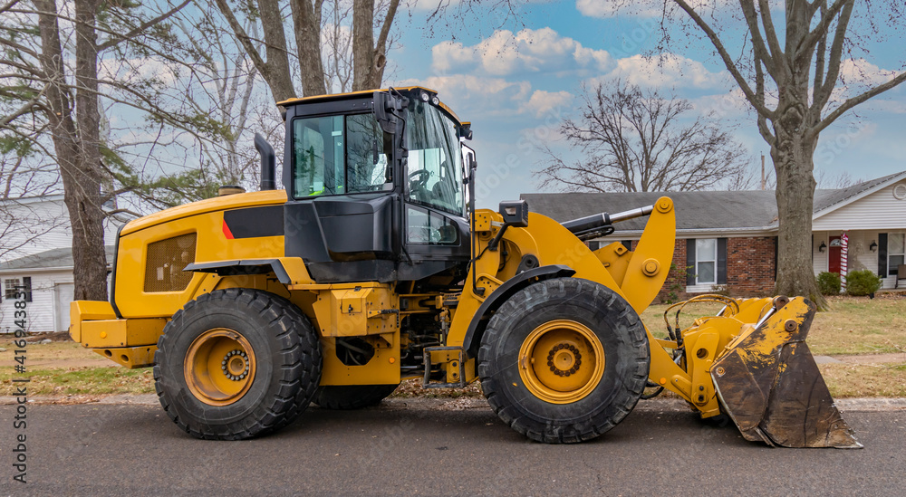 Heavy duty Front End Loader ready to work on Residential Street Heavy duty Front End Loader ready to work on Residential Street