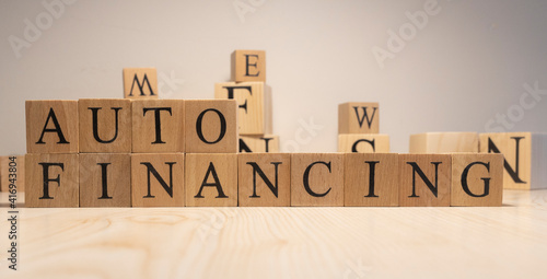 Auto financing word from wooden cubes. Background from wooden letters. Close up.