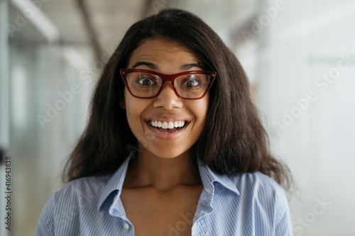 Close up portrait of smiling African American woman wearing stylish eyeglasses. Funny nerd student with open mouth looking at camera, education concept 